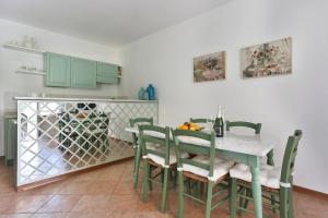 彼得拉桑塔Soleado beach house的用餐室配有带绿椅的桌子