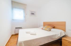 卡莱利亚德帕拉弗鲁赫尔CANADELL BAIXOS 3º的一间卧室配有一张大床和木制床头板