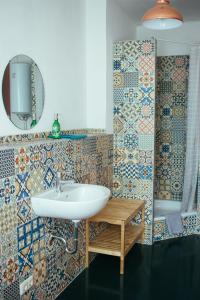莱比锡旅舍和伊甸花园的浴室设有水槽,墙上铺有瓷砖。