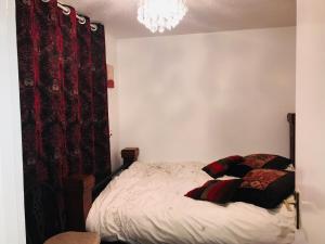 哈罗Modern cosy room with private bathroom的一间卧室配有床和红色窗帘