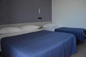 博尔迪盖拉小天堂酒店的两张位于酒店客房的床,配有蓝色床单