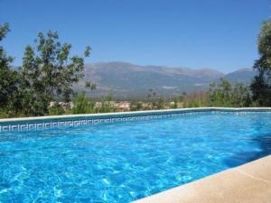 布埃纳文图拉Casa Rural Rincón de la Fuente的一个大型蓝色游泳池,后面是群山