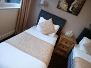 丁沃尔The Waverley Inn的一间卧室设有两张床和床头柜