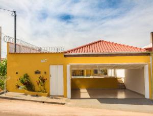 圣若昂-巴蒂斯塔-杜格罗里亚Pouso Oliveira Casa com ar condicionado的黄色房子,带车库