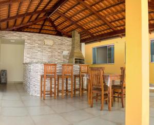圣若昂-巴蒂斯塔-杜格罗里亚Pouso Oliveira Casa com ar condicionado的一间带桌椅和壁炉的用餐室