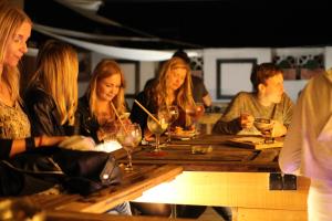 大加那利岛拉斯帕尔马斯Columbus Rooftop Hostel的一群坐在桌子上的人,戴着酒杯