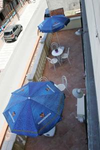 帕利努罗Casa Vacanze Rosy " Nel Centro"的阳台配有2把蓝色遮阳伞和桌椅。