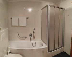 萨尔巴赫里佩尔公寓的带淋浴、卫生间和浴缸的浴室
