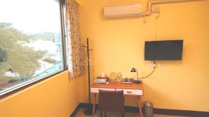 富里里山旅棧民宿 Li Shan Homestay的客房设有书桌、电视和窗户。