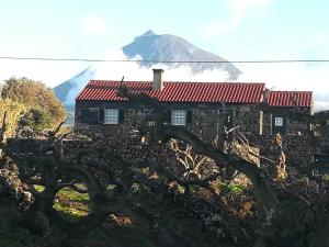 马达莱纳A Casa da Formosinha的一座古老的石头房子,背景是一座山