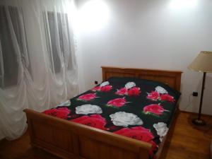 LyutibrodКъща за гости "Мечта"的一间卧室,床上有红色的鲜花