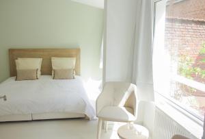 里尔梅特姆科莱住宿加早餐旅馆的卧室配有床、椅子和窗户。
