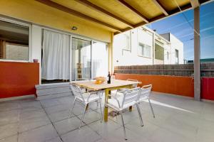 巴塞罗那Amplio apartamento con terraza en zona muy tranquila的天井上的木桌和椅子