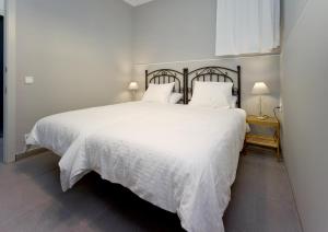 巴塞罗那Amplio apartamento con terraza en zona muy tranquila的卧室配有白色床单和白色大床