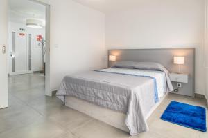 滨海保尔Casa das bonecas 2 # Private Garage Included #的白色卧室配有床和蓝色地毯