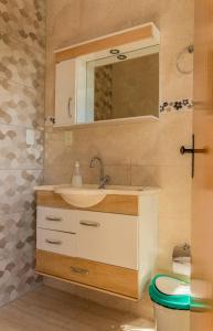 圣若昂-巴蒂斯塔-杜格罗里亚Pouso Oliveira Suítes的一间带水槽、镜子和卫生间的浴室