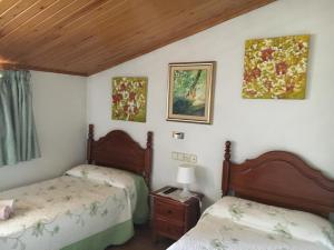 Vilaller方达山酒店的一间卧室配有两张床和一张桌子