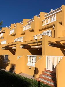 苏埃卡La casa del perelló的黄色的建筑,设有白色的阳台