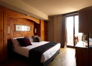 萨奥兹-杜尔克斯Chaberton Lodge & Spa的一间卧室设有一张大床和大窗户