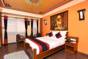 加德满都卡玛精品酒店的卧室配有一张床,墙上挂有绘画作品