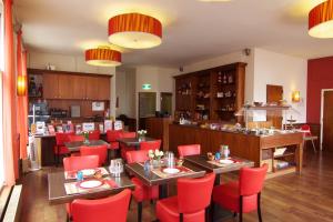 阿姆斯特丹城市酒店的一间餐厅,房间内设有红色的椅子和桌子
