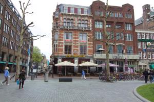 阿姆斯特丹城市酒店的一群人走在城市街道上,街道上有很多建筑