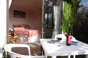 莱姆里吉斯Skerries B and B的庭院里的白色桌子和一瓶葡萄酒