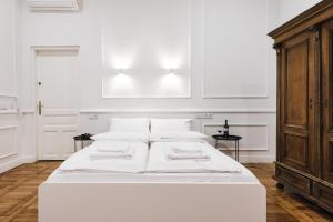 克拉科夫Old Time Apartments的客房内的白色床和白色枕头