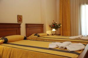 卡兰巴卡Famissi Hotel的两张位于酒店客房的床,配有毛巾