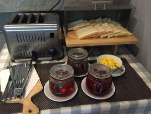 马卡萨马卡萨艾克普利西亚酒店的一张桌子,上面放有果酱盘子和面包,还有烤面包机