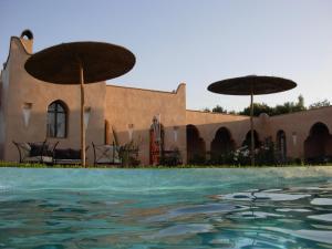 塔鲁丹特贾丹埃皮斯花园酒店的一座带游泳池和两把遮阳伞的房子