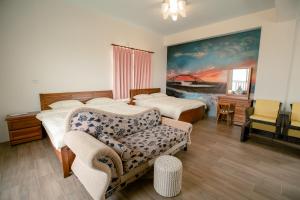 马公澎湖太阳民宿的一间卧室配有两张床、一张沙发和一把椅子