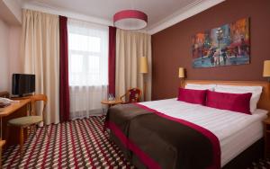 圣彼得堡欧克提亚布斯卡亚酒店的酒店客房配有一张带红色枕头的大床
