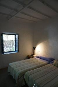 厄尔·坎皮洛·德·罗达尔Casa de la Buganvilla的一间卧室设有两张床和窗户。