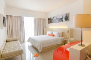 登巴萨登巴萨哈里斯酒店的酒店客房配有一张床和一张带台灯的书桌