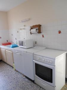 米尼赞海滩La palombe的厨房配有白色炉灶和微波炉