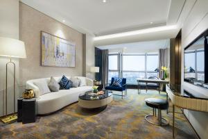 上海上海千禧海鸥大酒店的客厅配有白色的沙发和桌子