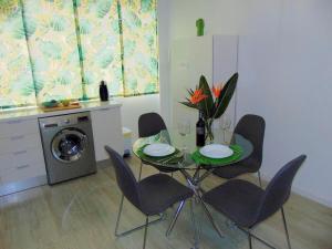 圣克鲁斯-德特内里费CASA PAPAGAYO的一间带桌椅和洗衣机的用餐室