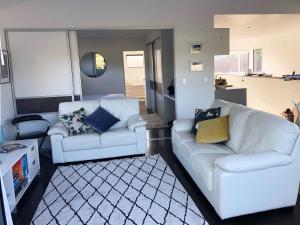 哈海Hahei Beach Apartment的客厅配有2张白色沙发和地毯。