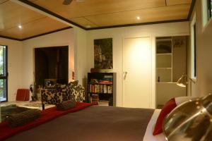 LamingtonWongari Eco Retreat的一间卧室设有一张床和一个书架