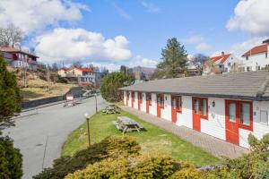 卑尔根Midttun Motell & Camping AS的一座有红白门和长凳的建筑