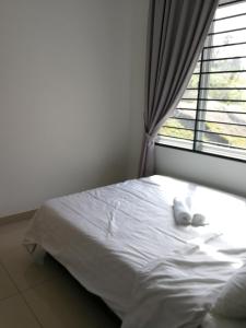 迪沙鲁Desaru Arcadia Semi D Rooms Rental Available的坐在窗前的床上的白泰迪熊