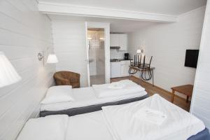 卑尔根Midttun Motell & Camping AS的白色客房 - 带两张床和椅子