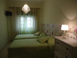 阿尔沃尔Quarto的一间卧室配有两张床、一张桌子和一盏灯。