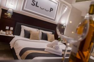 尼亚·蒙达尼亚索克拉提斯酒店的一间卧室配有一张床和葡萄酒杯