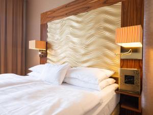 维也纳杰斯霍夫阿姆拉特斯酒店的一张带白色枕头的床