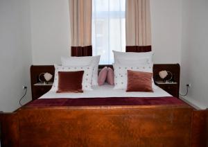 克拉科夫Castle View Boutique Apartment的一间卧室配有一张带木制床头板和枕头的床。