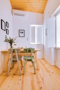 法鲁A Casa D'Amelie的一间带木桌和两把绿色椅子的用餐室