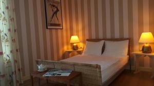 马斯丹B&B de Oude Hofstee的一间卧室配有一张带两盏灯和一张桌子的床。