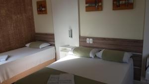 拉热阿杜HOTEL MARIANI的一间小房间,房间内设有两张床